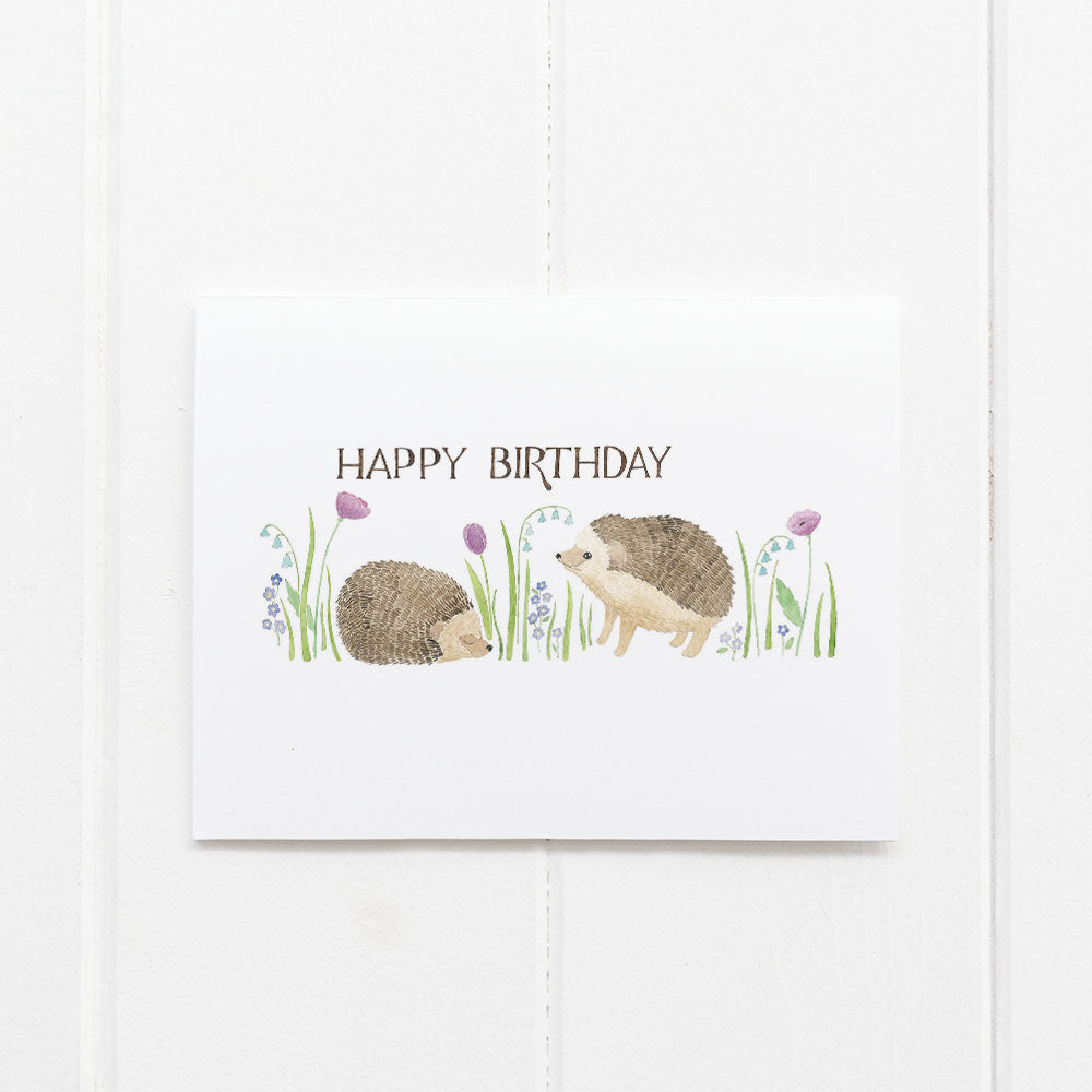Hedgehogs Birthday Card featuring watercolor hedgehogs and flowers with a hand-lettered birthday message, blank inside, includes a kraft envelope.