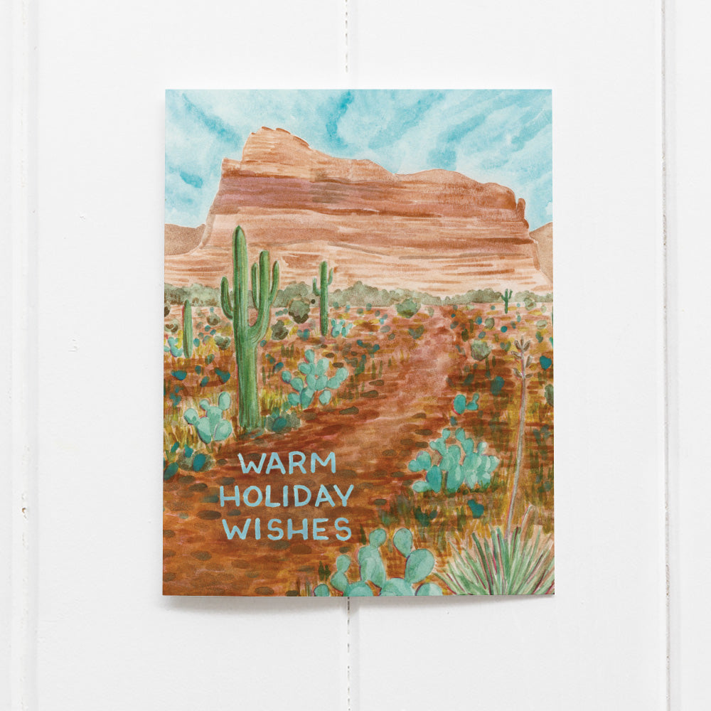 Warm Holiday Wishes Card featuring a watercolor desert landscape with cacti and mountains, inspired by Sedona. Blank inside, includes a kraft envelope.