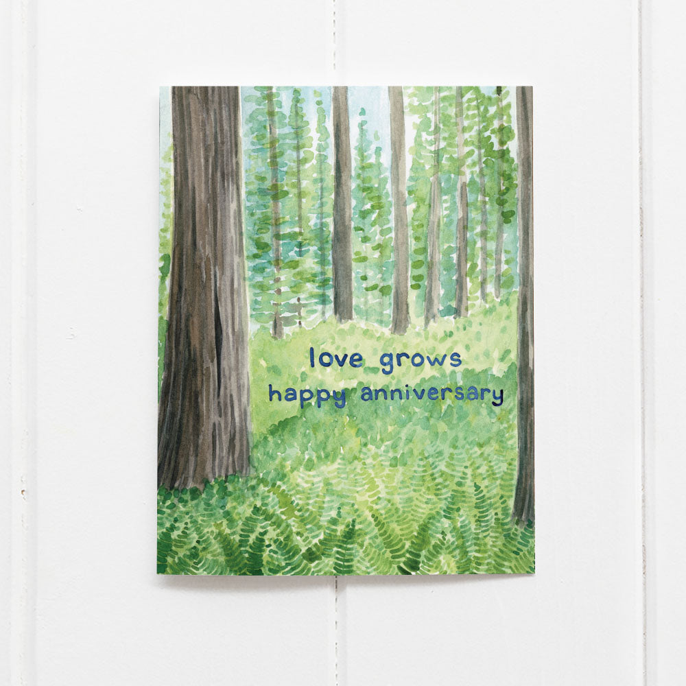 Love Grows Anniversary Card featuring a watercolor illustration of redwood trees and ferns, printed on recycled cardstock, blank inside, includes kraft envelope.