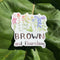 Brown And Flourishing Sticker: Vinyl sticker featuring watercolor wildflowers and hand-lettered text, ideal for personalizing items like laptops or water bottles.