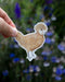 Hand holding a Polish Hen - Watercolor Chicken Sticker featuring a watercolor illustration of a Polish Chicken hen by artist Brigida Swanson.