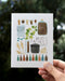 Father's Day Homebrew Card depicting beer and homebrewing equipment in a watercolor illustration, held by a hand, printed on recycled cardstock with a blank interior.