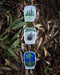 Connection Trees Sticker: Vinyl sticker with watercolor illustration of evergreen trees and CONNECTION text. Suitable for laptops or water bottles. Art by Brigida Swanson.