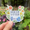 Hand holding a Queer Voter Sticker featuring watercolor flowers in rainbow colors, symbolizing LGBTQ+ pride and voter identity.