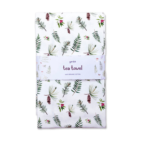 Pine and Cedar Tea Towel - Organic Cotton Kitchen Towel featuring botanical pine and cedar illustrations, wrapped in a paper band, with a corner hang loop.