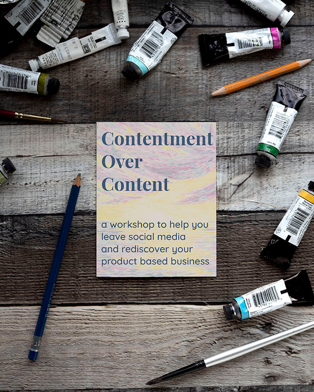 Paint tubes and pencils on wood surface, representing the Contentment Over Content workshop aimed at fostering contentment-based entrepreneurship beyond social media strategies.