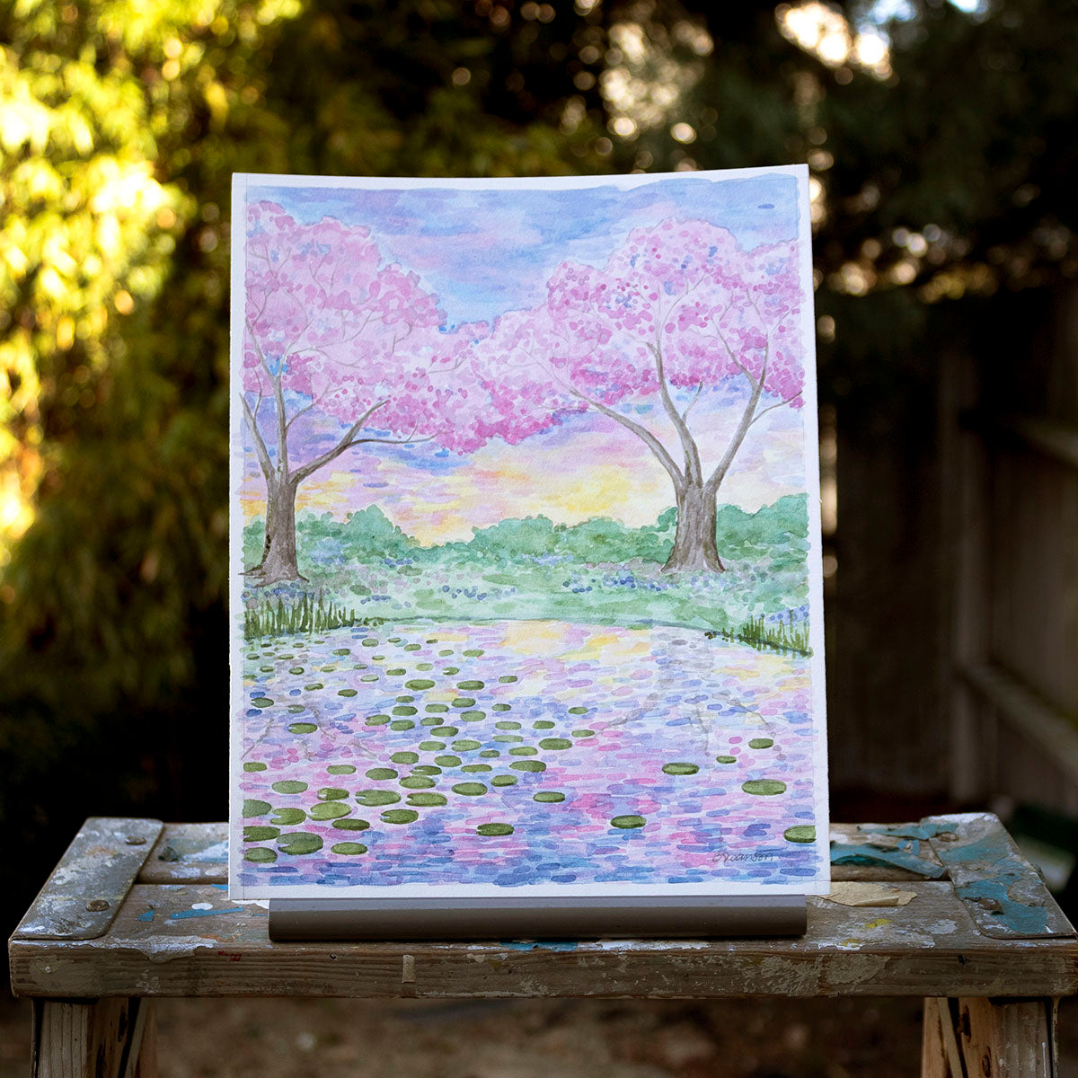 original watercolor painting of a waterlily pond and cherry blossom trees