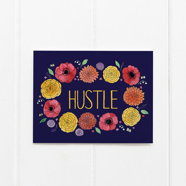 Hustle Card featuring a blue rectangular sign adorned with a flower garland illustration and motivational message, printed on recycled cardstock with a kraft envelope.