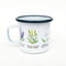 Wildflowers Camp Mug featuring Pacific Northwest wildflowers illustration on a white enamel mug with a black rim, suitable for camping and cozy beverages.