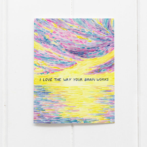 Neurodiversity Love Card featuring a watercolor rainbow sunrise and hand-lettered text, I love the way your brain works, by artist Brigida Swanson.