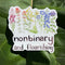 nonbinary and flourishing sticker on rhubarb leaf in sunshine