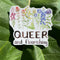 queer and flourishing sticker on rhubarb leaf in sunshine