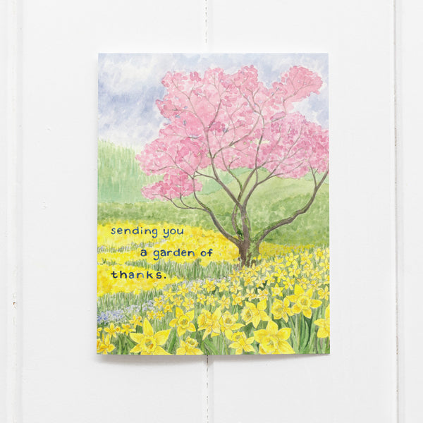 Watercolor daffodils and cherry blossom tree on thank you card reading Sending you a garden of thanks
