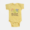 butter yellow baby one piece with Black and flourishing floral design