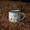 enamel camp mug with mushroom illustrations on forest floor
